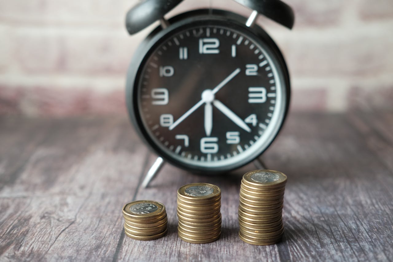 services-04 Stacked coins and a classic alarm clock symbolize the value of time and money.